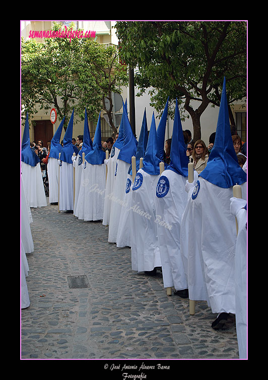 Cirios blancos para los nazarenos del cortejo del paso de Palio de la Hermandad de Cristo Rey en su Triunfal Entrada en Jerusalén