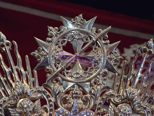 La ráfaga de la Corona de María Santísima de la Paz en su Mayor Aflicción se remata con el Escudo de la Hermandad en su parte superior