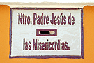 Buzón de limosna debajo del azulejo de Nuestro Padre Jesús de  las Misericordias en la Parroquia de Santa Ana