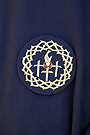 Escudo de la Hermandad sobre el antifaz de los nazarenos de la Hermandad del Santísimo Cristo del Perdón