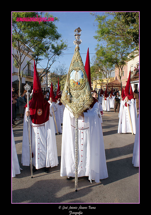 Nazareno portando el Banderín de la Aparición de la Virgen en Fátima de la Hermandad de la Paz