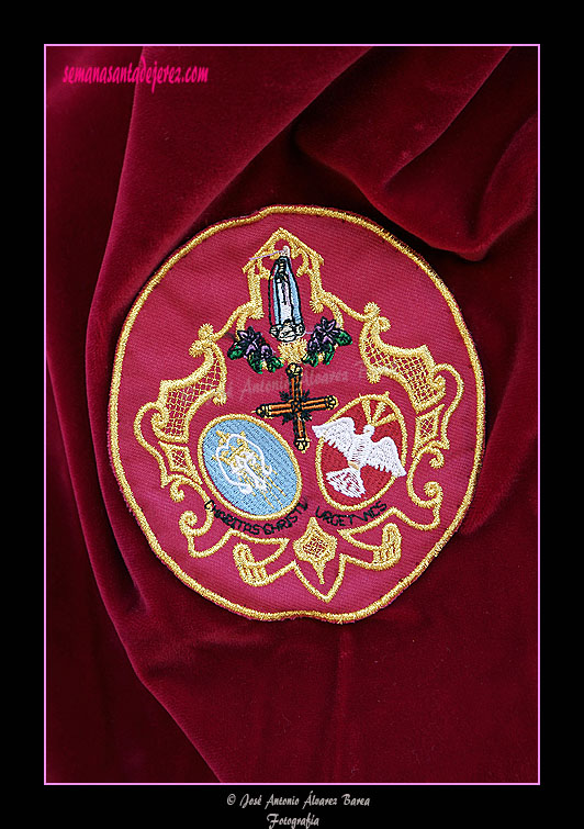 Escudo sobre el antifaz de los nazarenos de la Hermandad de la Paz de Fátima