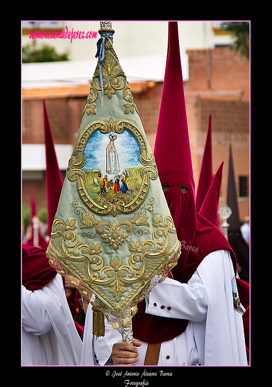 Nazareno portando el Banderin de la Aparicion de la Virgen en Fátima de la Hermandad de la Paz