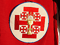 Escudo de la Hermandad en la capa de los nazarenos de la Hermandad de la Sagrada Cena
