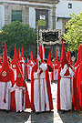 Nazareno portando el Banderín conmemorativo del XXV aniversario de la reorganización de la Hermandad de la Sagrada Cena