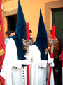 Nazarenos con portahachones de velas rojas acompañan al Banderín Eucarístico de la Hermandad de la Amargura