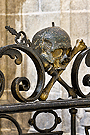 Cráneo con tibia y cetro en la reja del Retablo de Ánimas (Iglesia de San Miguel)