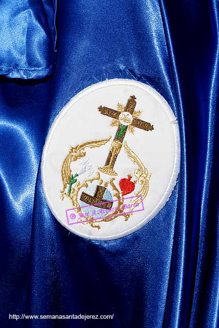 Escudo sobre la capa de un nazareno de la Hermandad del Cristo de Exaltación