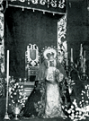 Nuestra Madre y Señora de la Soledad en ceremonia de Besamanos. El manto es el antiguo de corte dieciochesco. Sobre el frontal del dosel aparecen los bordados de mediados de los años 40 del siglo XX de la caida del palio. (Fotografía: Anonima).