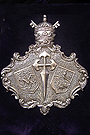 Escudo de la Hermandad en orfebreria sobre el Libro de Reglas de la Hermandad de la Soledad 
