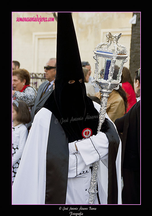 Nazareno con cirial de respeto acompañando al Simpecado de la Hermandad de la Coronación de Espinas