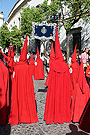 Nazareno portando el Banderín conmemorativo del XXV aniversario de la reorganización de la Hermandad de la Sagrada Cena