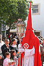 Nazareno portando un cirial de respeto que acompaña a la Bandera de la Virgen de la Hermandad de la Sagrada Cena