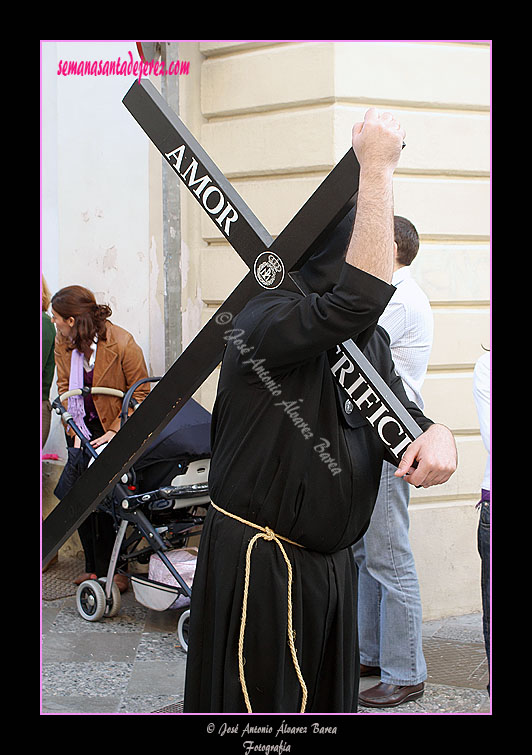 Penitente con cruz de la Hermandad de Nuestra Señora de Amor y Sacrificio