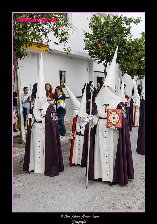 Nazareno portando el Libro de Reglas de la Hermandad de la Entrega