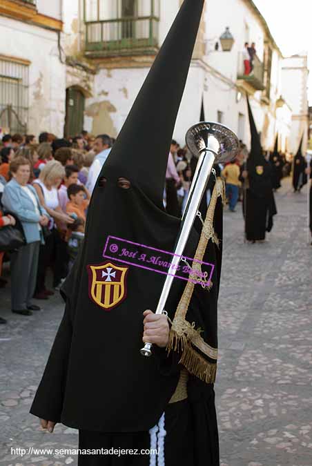 Nazareno portando una bocina de la Hermandad de las Tres Caídas