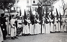 La Hermandad del Mayor Dolor está terminando la Estación de Penitencia: el cortejo del Señor está a las puertas del Templo del Patrón de la Ciudad. La foto es posterior a 1952, pues en este año se colocó el azulejo de la Virgen en la plaza-compás de la Iglesia Parroquial (Foto: Manuel Pereiras Hurtado)