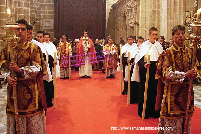 Preste acompañado de acólitos tras el paso de Palio de María Santísima de la Encarnación