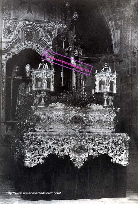 El paso de misterio de la Hermandad de las Cinco Llagas esperando en la Colegial a que "pase la lluvia"