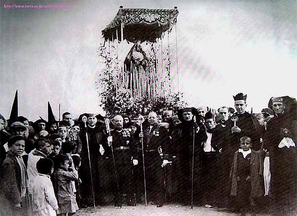 Años 20. La Virgen del Valle con palio de ocho varales.Se observan hermanos con la túnica de Jesús Nazareno al fondo de la imagen. Los bordados del palio son hoy propiedad de una Hermandad de Rota