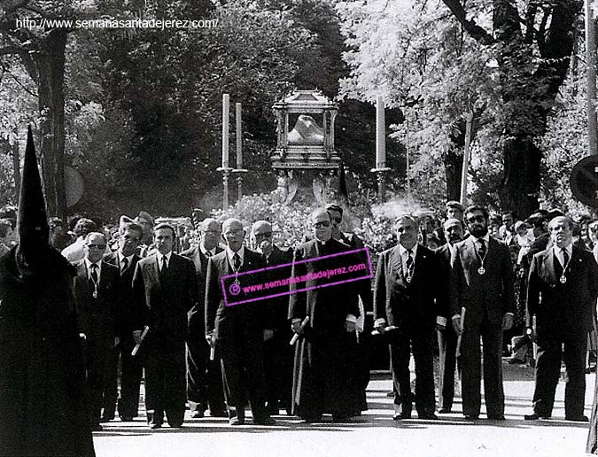 Presidencia de la Unión de Hermandades en la procesión del Santo Entierro en los primeros años de la década de los 80. En ella podemos apreciar en el centro al sacerdote D. Antonio Bernal Verdugo. El presidente del Consejo era D. Juan Huertas, acompañado de D. Bernardo Linares, D. Manuel Serrano, D. José Alfonso Fernández, D. José García Soto, D. José Pérez Raposo, D. Francisco Rodríguez Romero y D. José Luis Ferrer (Foto: Anónimo)