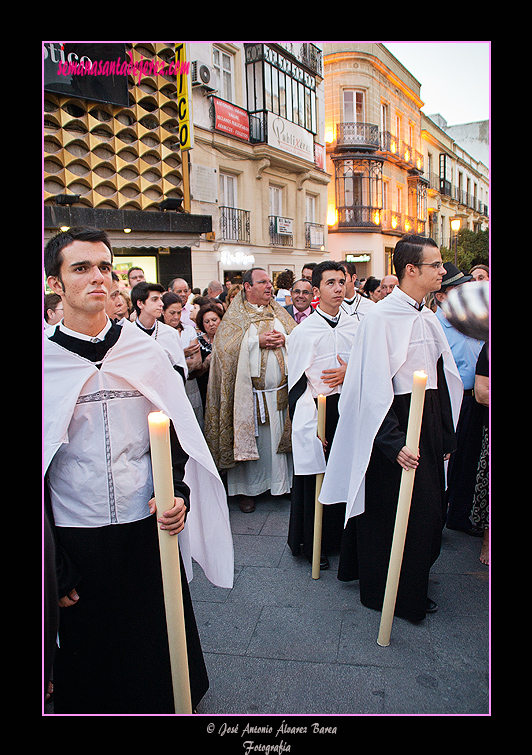 Preste y acólitos tras el Paso de la Virgen del Carmen